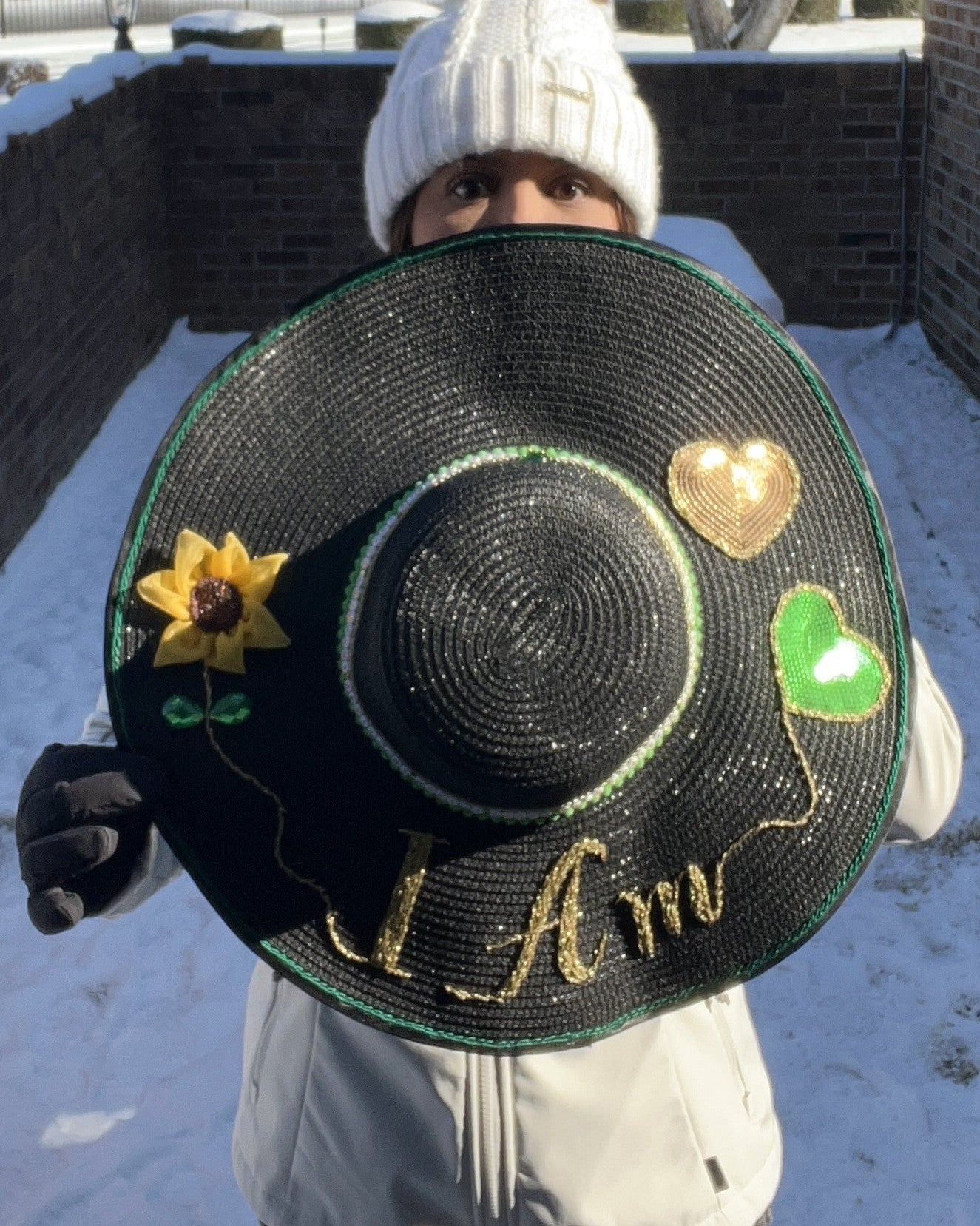 Hand embroidered affirmation detail on Manifest Hat, photographed in winter snow
