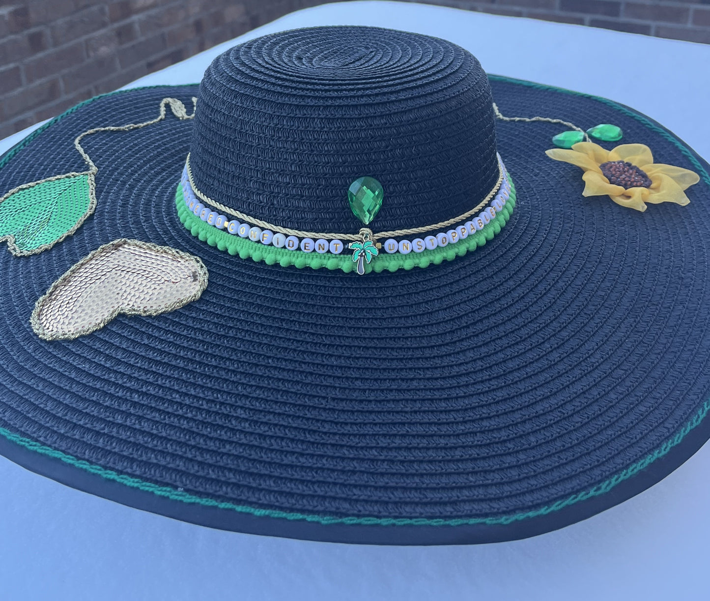 Hand embroidered affirmation detail on Manifest Hat, photographed in winter snow